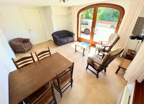 un salon avec une table et des chaises en bois dans l'établissement Appartement 4 couchages à proximité du plan d'eau, à Saint-Sauveur