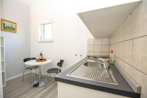 a kitchen with a sink and a small table at Apartments Mosor in Omiš