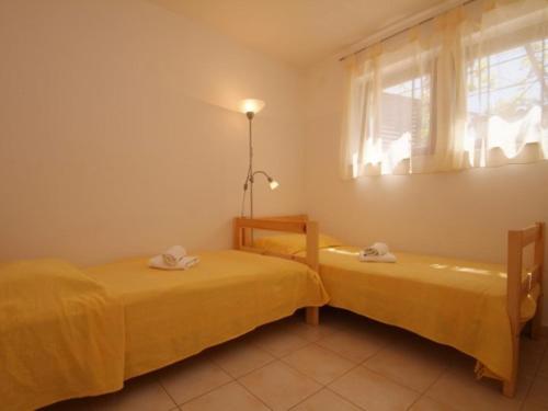 two beds in a room with a window at Diklo beach apartments 1 in Zadar