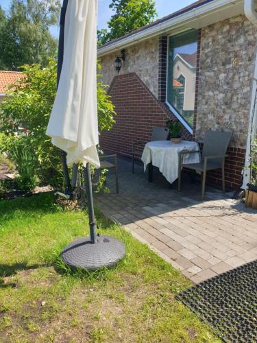 an umbrella sitting in the grass next to a patio at Brīvdienu mājas in Jūrmala