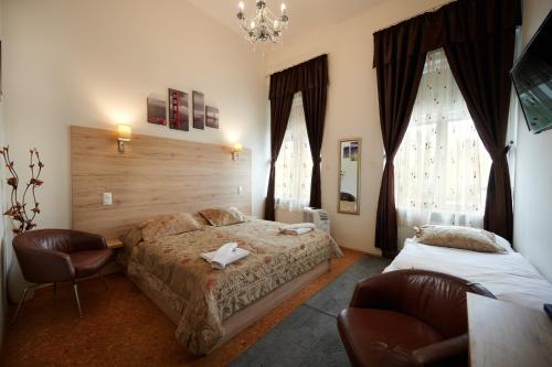 a bedroom with two beds and a chandelier at Vinci Apartman Szombathely in Szombathely