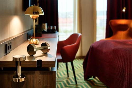 a room with a bed and a table with a lamp at ProfilHotels Halmstad Plaza in Halmstad
