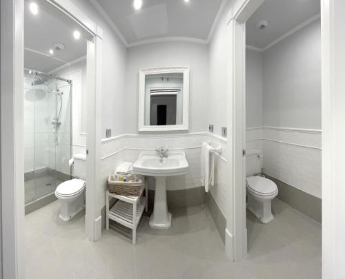 a white bathroom with a sink and a toilet at Apartamentos El Mirador del Poeta in Salamanca