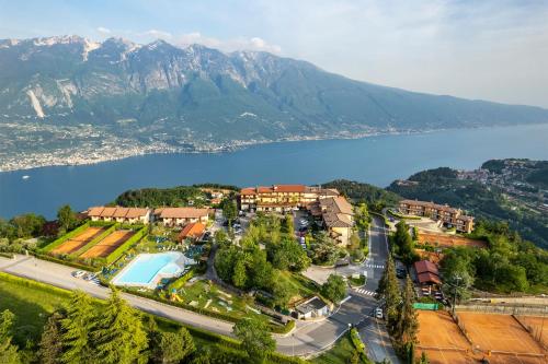 an aerial view of a resort with a lake and mountains at Hotel Pineta Campi in Tremosine Sul Garda