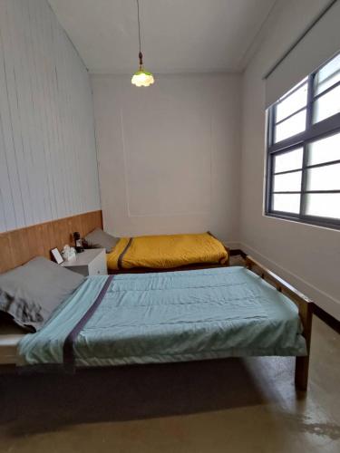 a bedroom with two beds and a window at 樓仔厝 in Xiaoliuqiu