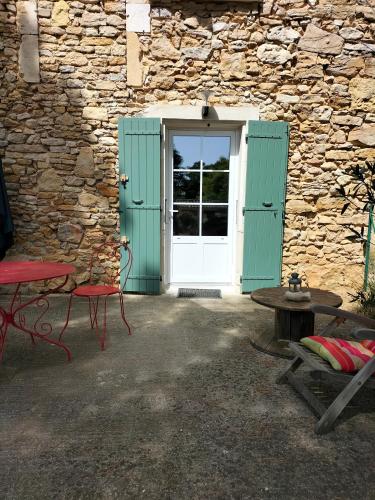 eine Tür zu einem Steingebäude mit einem Tisch und einer Bank in der Unterkunft Chambre Malon Mas Bel Esperance in Saint-André-dʼOlérargues
