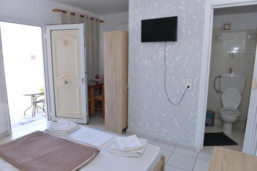 アダマスにあるBlue Roomsのバスルーム(トイレ付)、壁にテレビが備わります。