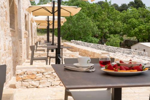 a table with a plate of fruit and a glass of wine at DONNAPAOLA MODERN FARM in Altamura