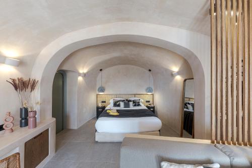 a bedroom with a bed and a tub in a room at The Exotic Cave Suite in Oia
