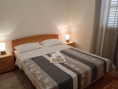 1 dormitorio con 1 cama con 2 toallas y 2 lámparas en Apartments Aferdita, en Račišće