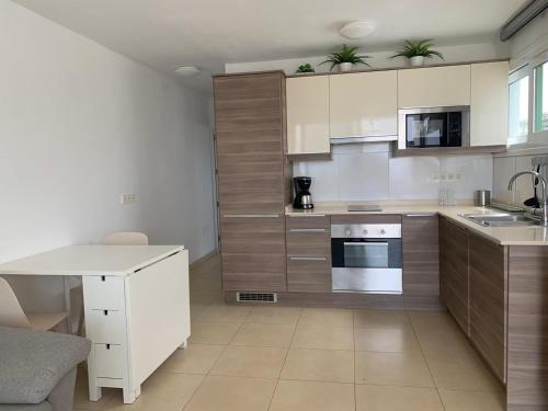 una cocina con electrodomésticos blancos y armarios de madera en SEA&RELAX en Puerto del Carmen