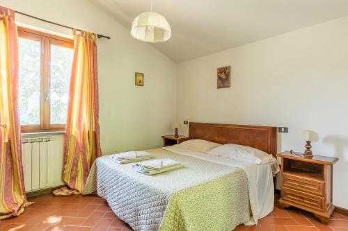 a bedroom with a bed and a window at Abadia Farneto in Gubbio