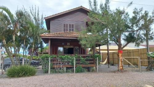 a house with a fence in front of it at La Tatuira, Cabana Amarela in Pinheira