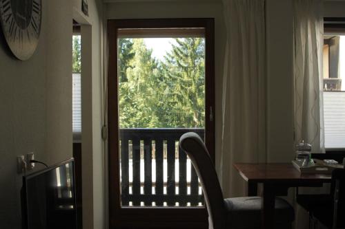 a door to a balcony with a table and a window at Alpendomizil Pia in Mühlbach am Hochkönig