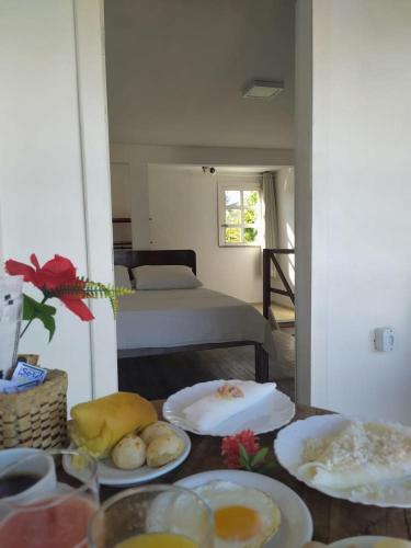a room with a bed and a table with plates of food at Casarão Jeri in Jericoacoara
