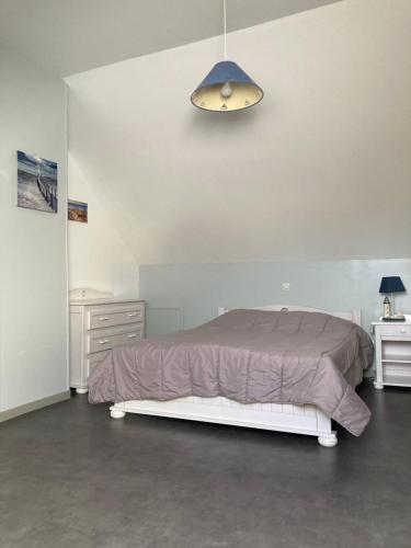 een slaapkamer met een bed met een paars dekbed bij La Garenne in Camiers