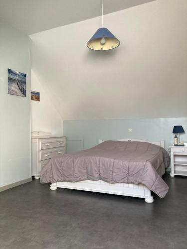 a bedroom with a bed with a purple comforter at La Garenne in Camiers