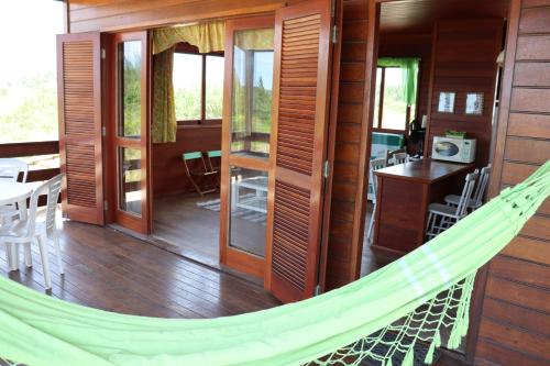 a hammock in the center of a room with a table at La Tatuira, Cabana Amarela in Pinheira