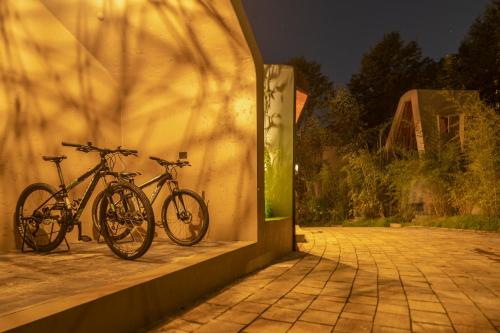 dos motos estacionadas junto a una pared por la noche en Kavya Resort & Spa, en Nagarkot