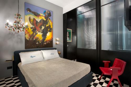 a bedroom with a bed and a red chair at CocoMorghen Apartment in Naples