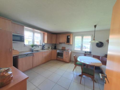 a kitchen with wooden cabinets and a table with chairs at Klettgauperle - familien- und behindertengerechte Ferienwohnung in Griessen