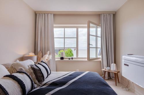 a bedroom with a bed and a large window at Nidos Banga in Nida