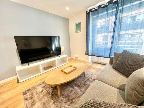 Una sala de estar con un sofá y un televisor de pantalla plana. en Appartements meublés Brest Saint Marc, en Brest