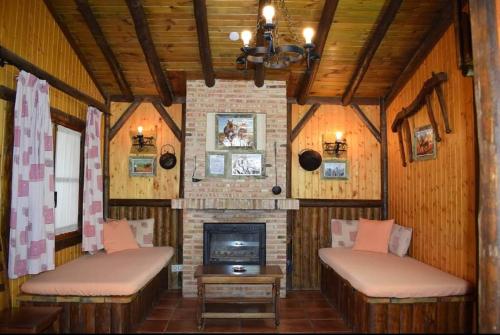 a living room with two benches and a fireplace at El Mirador de la Mancha in Villarrubia de los Ojos