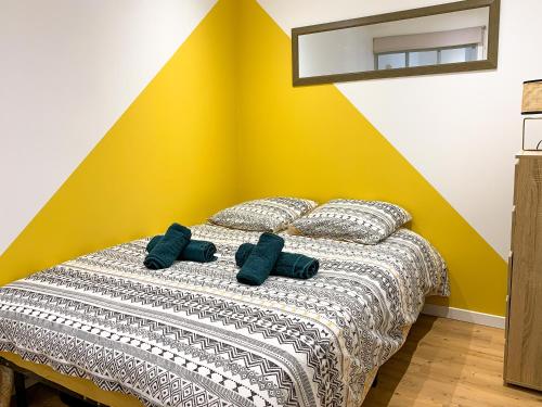 um quarto com uma cama com duas almofadas azuis em Nid douillet em Buxy