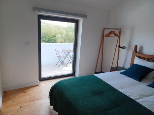 a bedroom with a bed and a window with a patio at ADEGA Residências Artísticas - Perto de Lisboa in Almargem