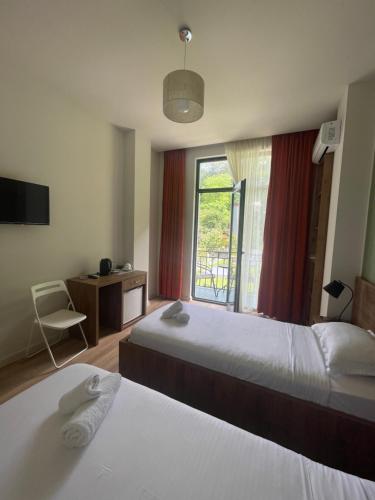 a hotel room with two beds and a window at Villa Flora in Gonio