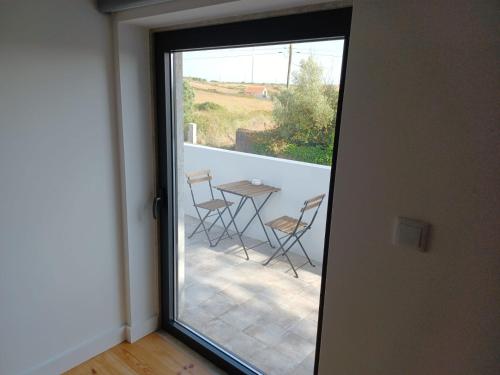 a door leading to a patio with a table and chairs at ADEGA Residências Artísticas - Perto de Lisboa in Almargem