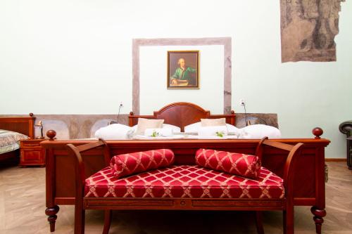 a bed with a red bench with a red cushion at Wellness hotel Rezidence in Nové Hrady