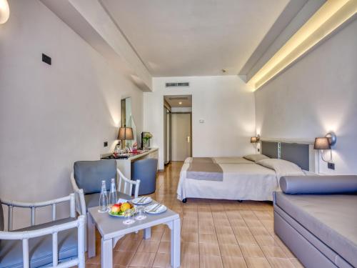 a hotel room with a bed and a couch at Hotel Olimpo le Terrazze in Letojanni