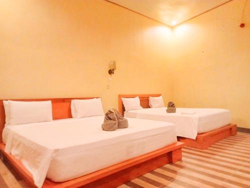 two beds in a room with at Tangkoko Ranger Homestay in Bitung