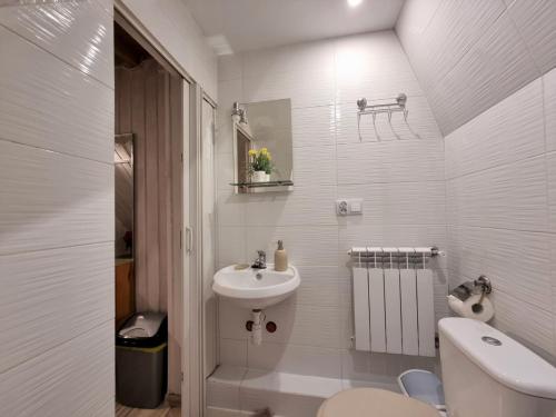 a white bathroom with a sink and a toilet at Ostoja pod Tatrami in Poronin