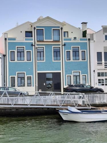 a boat in the water in front of a building at Light Blue Apartment in Aveiro