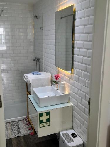 a bathroom with a sink and a mirror at Light Blue Apartment in Aveiro