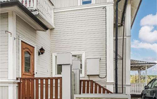 a white house with a porch and a balcony at Cozy Apartment In Torsåker With Wifi in Stjärnsund