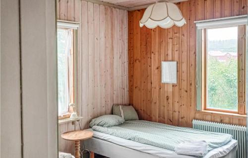 1 dormitorio con 1 cama en una pared de madera en Cozy Apartment In Torsker With Wifi en Stjärnsund