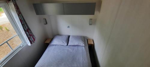 Cama pequeña en habitación pequeña con ventana en Mobil-Home 6 pers sur une grande parcelle, proche Paris camping 3 étoiles, en Mirgaudon