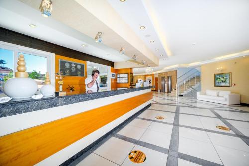 a large lobby with a long counter and a person at Villa Sunflower Hotel - All Inclusive in Alanya