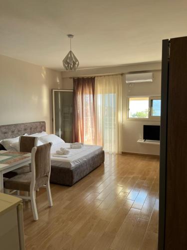 a bedroom with a bed and a table with a chair at Lotus Apartments in Vlorë