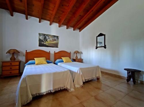 two beds in a room with white walls and wooden floors at Ca n'Antonia in Sant Ferran de Ses Roques