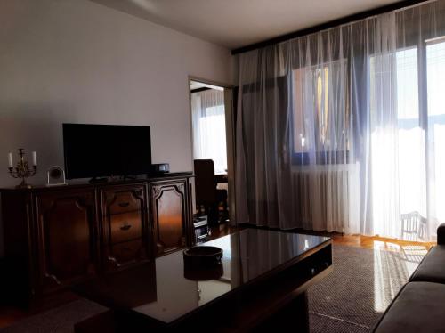 a living room with a tv and a couch and a table at apartman dobrinja2 in Sarajevo