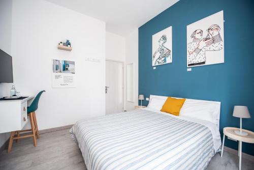 1 dormitorio con cama y pared azul en Blunotte Torino - Piazza Arbarello en Turín