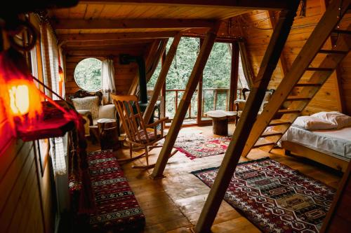 a attic room with a bed and stairs in a cabin at Moromu Bungalows in Çamlıhemşin