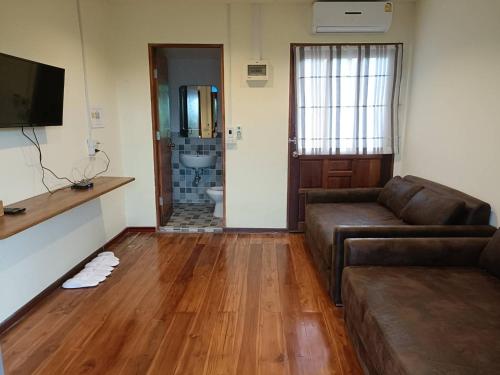 a living room with a couch and a television at Maingern Maithong Resort in Sara Buri