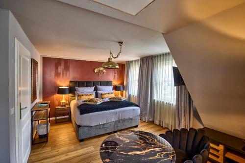sypialnia z łóżkiem i biurkiem oraz łóżko o wymiarach 6 x 6 x 6 w obiekcie Hotel Belvedere w mieście Warnemünde