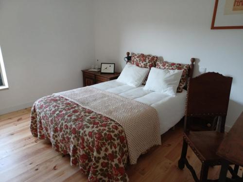 a bedroom with a bed and a wooden floor at ADEGA Residências Artísticas - Perto de Lisboa in Almargem